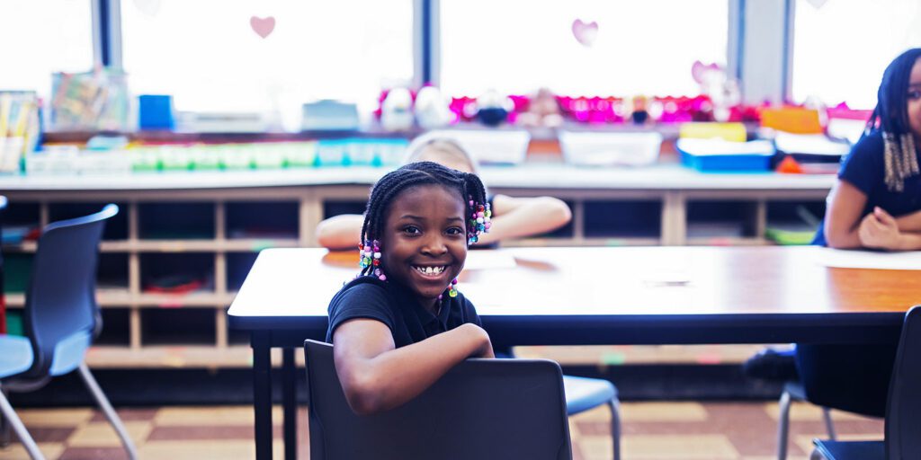 Smiling student sitting at a desk.