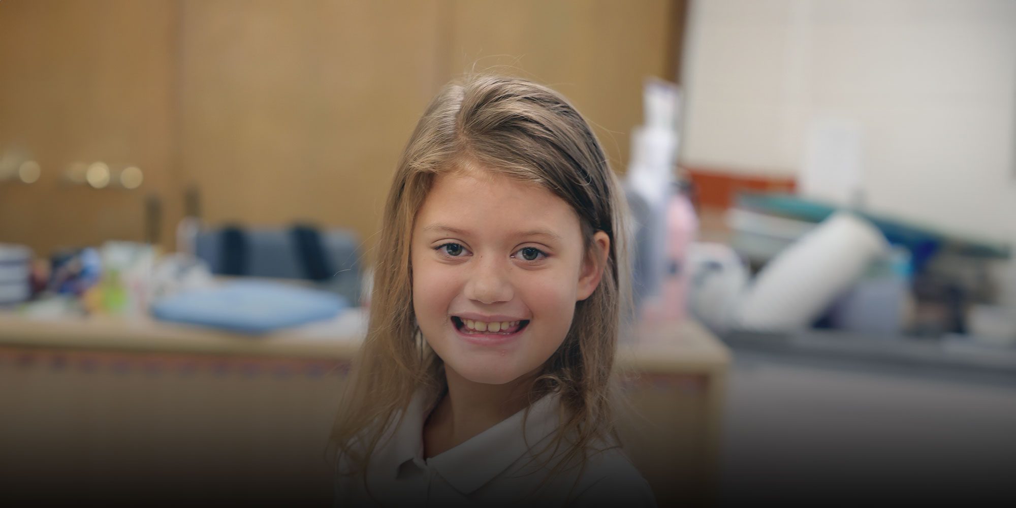 Smiling student sitting at table in classroom