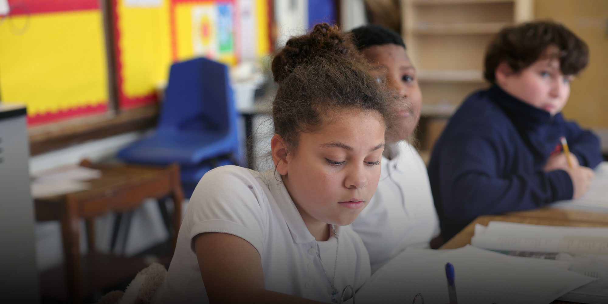 Student writing at desk