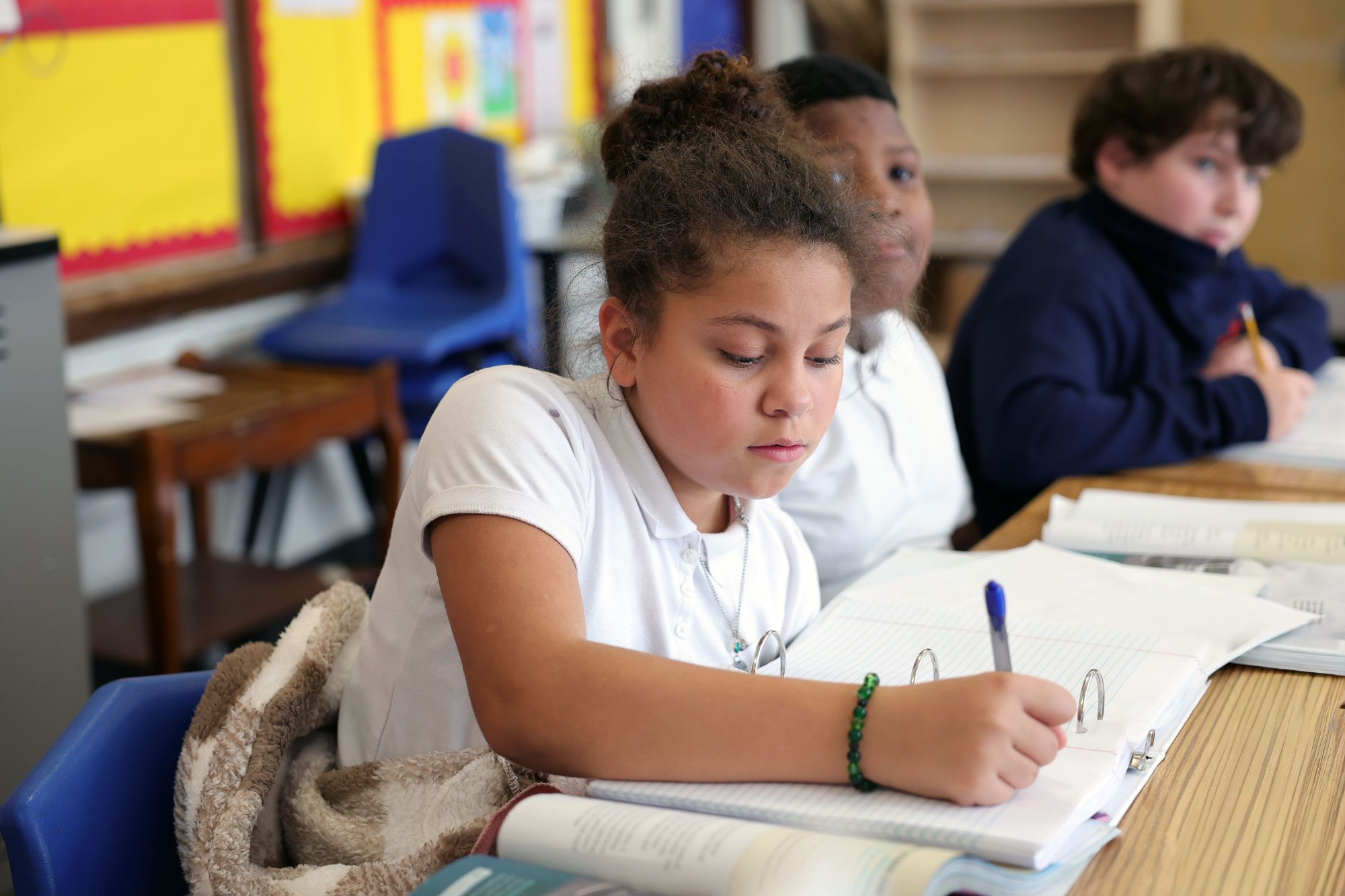 Student writing at desk